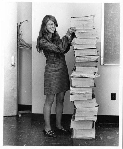 Margaret Hamilton standing next to the code she wrote that took Neil Armstrong to the moon